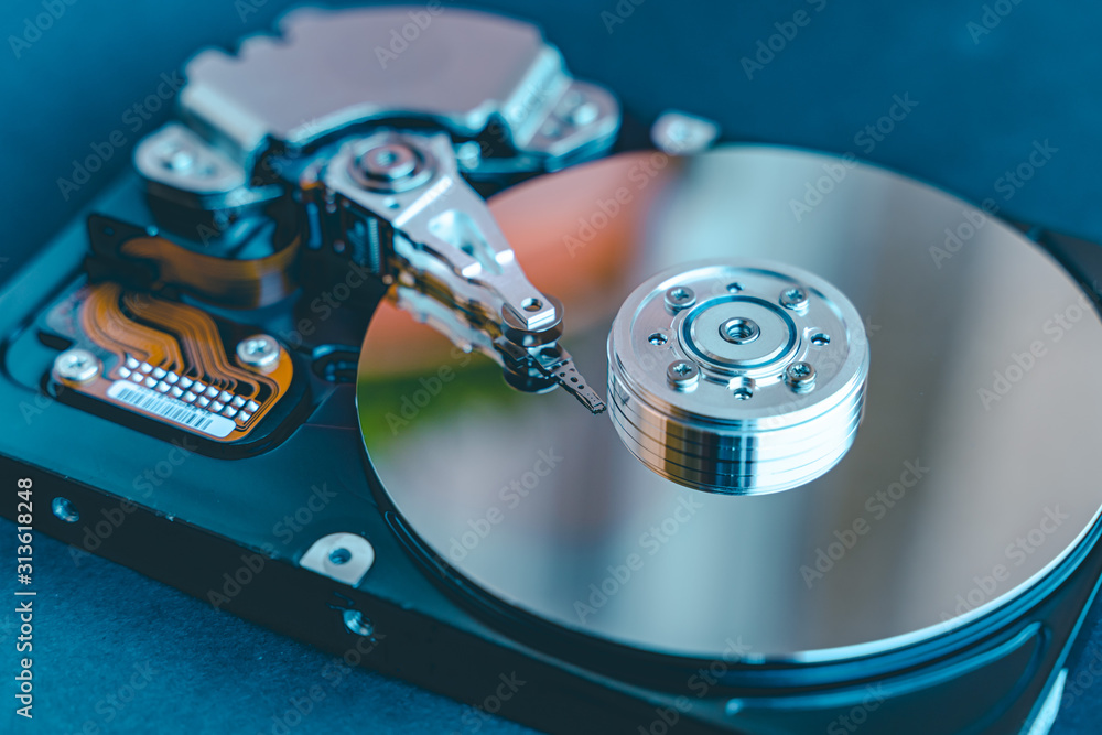 Hard disk drive platter.Disassembled hard drive from the computer with  mirror effect. HDD) .Detail of writing/reading head on actuator arm and  axis, spindle and platters. Stock 写真 | Adobe Stock