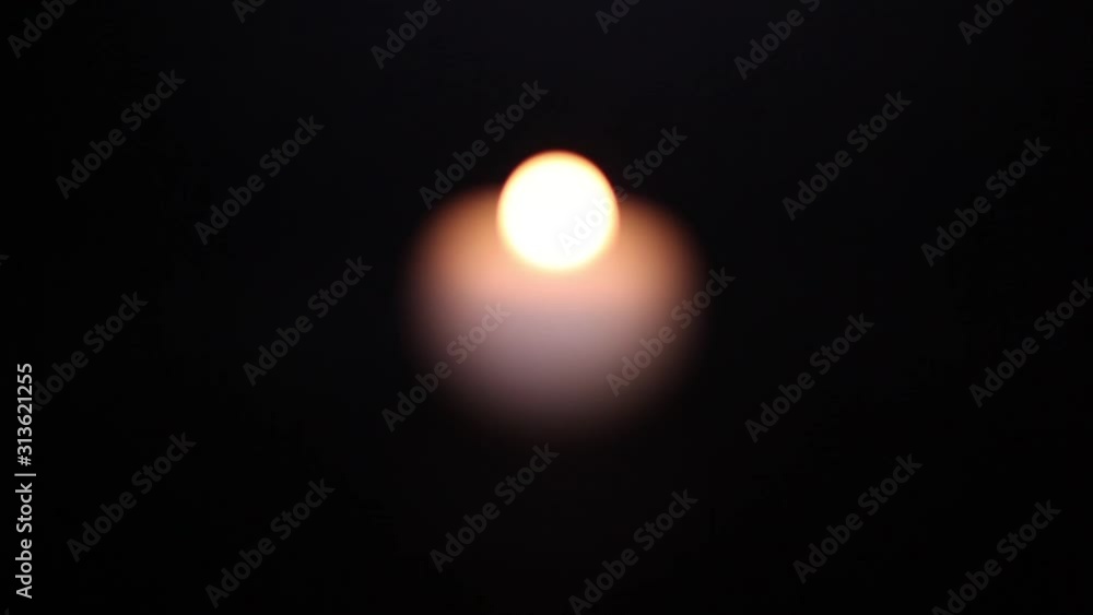 Сandle burns on a black background, standing alone in the dark from focus to focus. Сandle burns on a black background, standing alone in the dark from focus to focus.