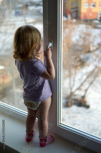 A little girl standing in front of a window