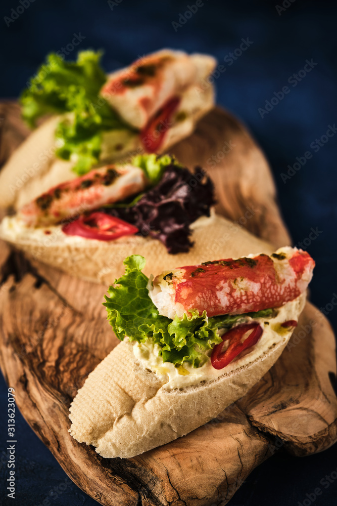 Bruschetta with butter, crab and chili on a wooden board.