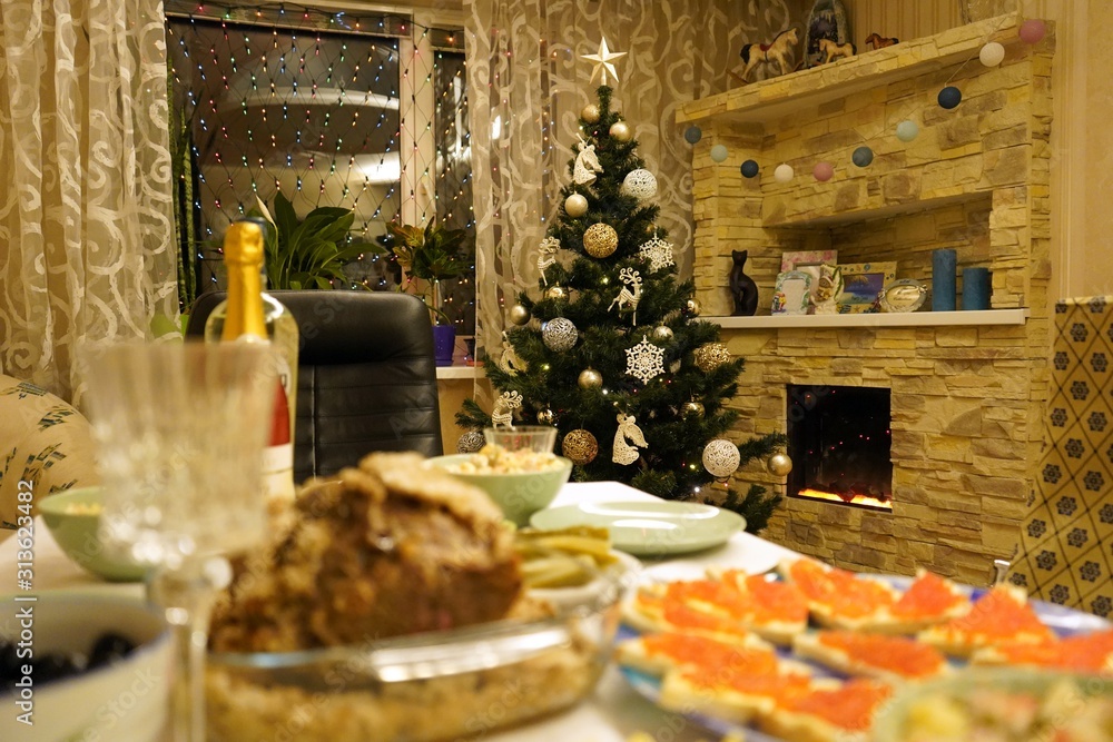 Dishes with food on the New Year's holiday table. New Year's holiday table. Salads, meat, alcohol on the New Year's table.