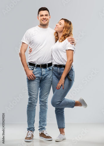 relationships and people concept - portrait of happy couple in white t-shirts over grey background