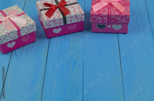 Three gift boxes on bule wooden background. Place the gift box in the upper right corner to allow space for the greeting text below.