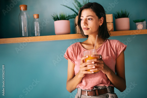 Happy beautiful smiling woman drinking detox moothie.