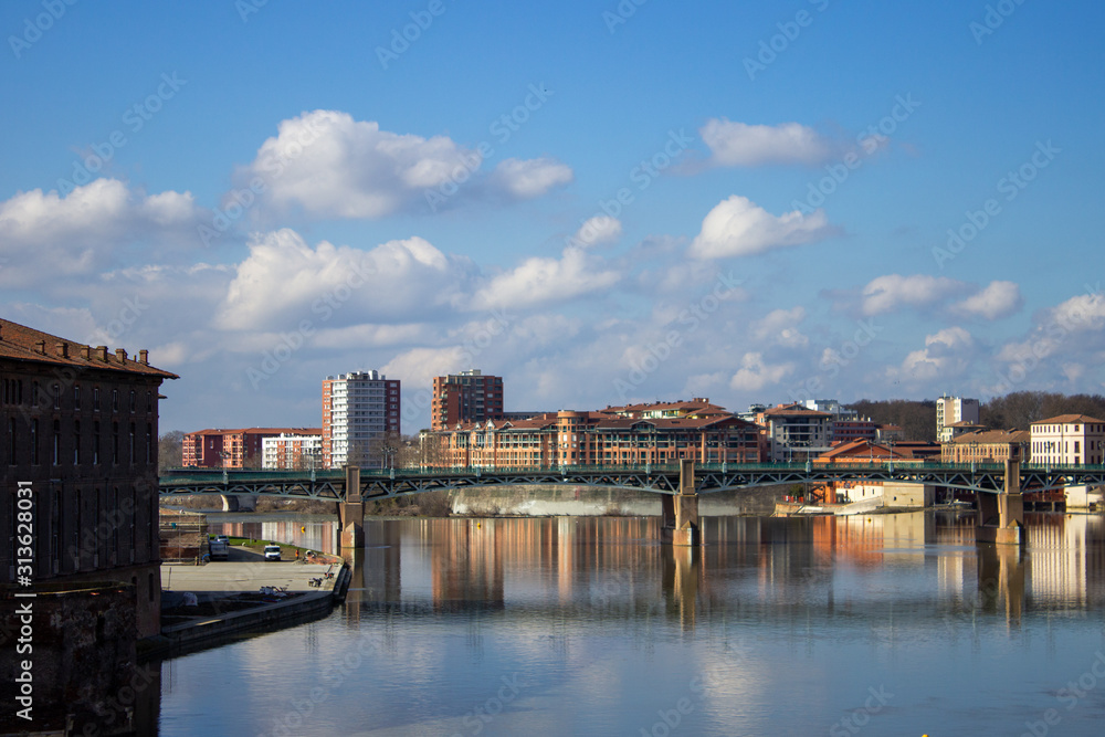 Landscape of a city and a bridge in France with reflection of the buildings in the river