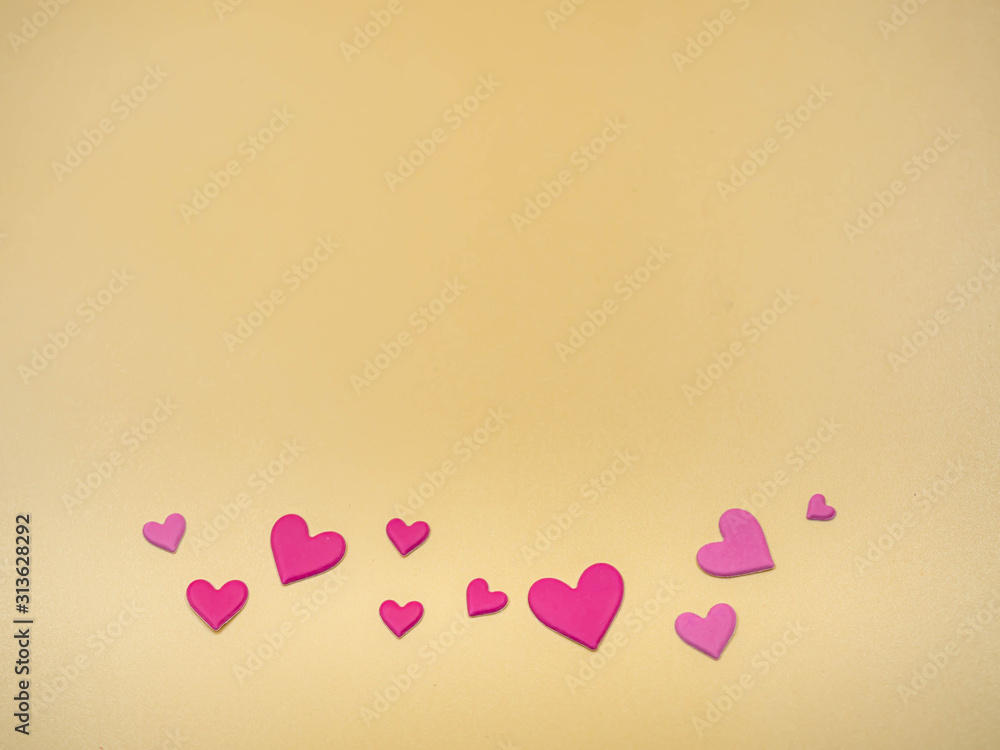 Pink heart shape paper stickers on golden color background for valentines day, love, wedding concept and idea.