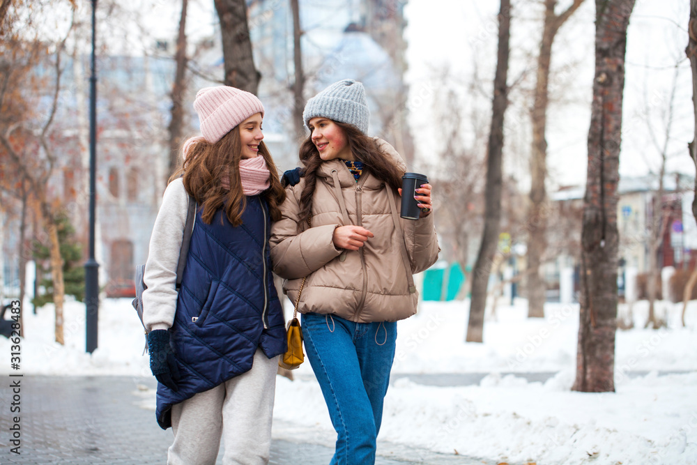 Close up portrait of two young girls walking in a winter park Close up portrait of two young girls walking in a winter park