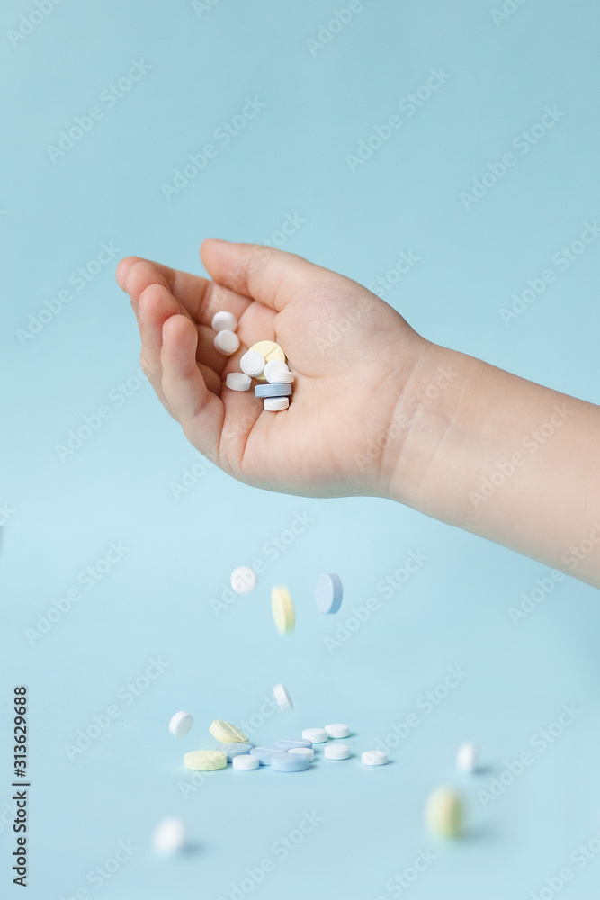 yellow, blue and white pills fall from the hand yellow, blue and white pills fall from the hand