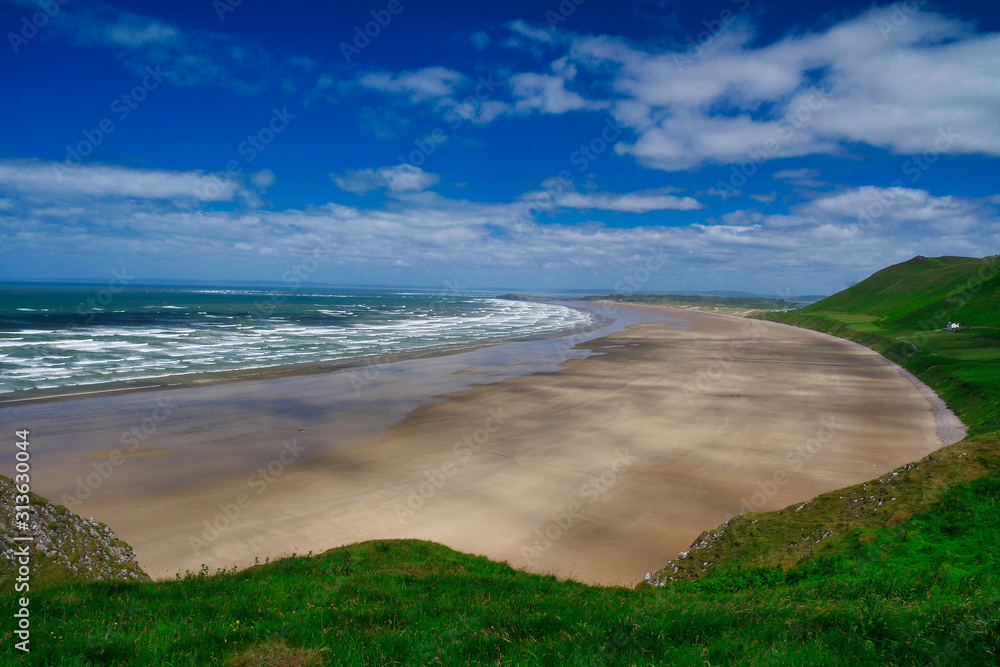 Rhossili Bay beach on the Gower Peninsula in South Wales in the UK, on a sunny day in summer. Rhossili Bay beach on the Gower Peninsula in South Wales in the UK, on a sunny day in summer.