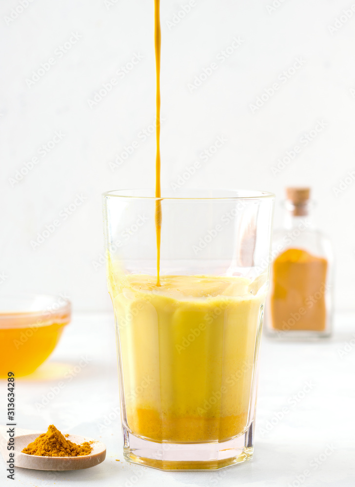 milk tea with turmeric and honey on a white background milk tea with turmeric and honey on a white background
