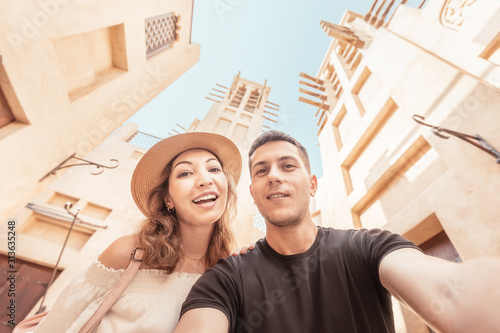 Photography A happy couple takes a selfie against the backdrop of ancient Arabic architecture in the old town of Dubai