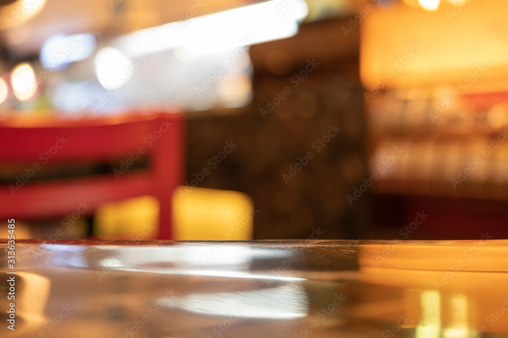 A gloss polish table top finishing in the coffeeshop with red chair blur background A gloss polish table top finishing in the coffeeshop with red chair blur background