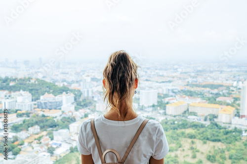 Fototapeta Naklejka Na Ścianę i Meble -  Young caucasian woman looking at the city from the heights
