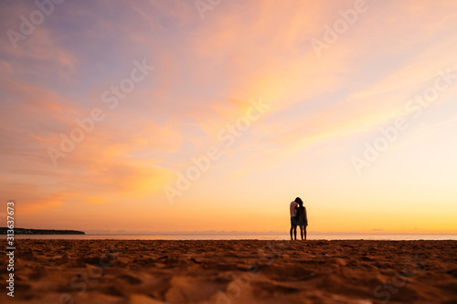 Couple kissing on the beach with a beautiful sunset