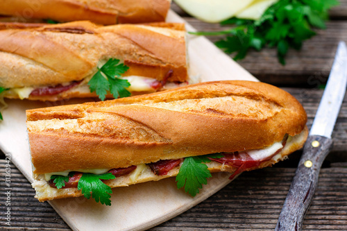 Oven baked baguette sandwich with cheese, ham and tomato