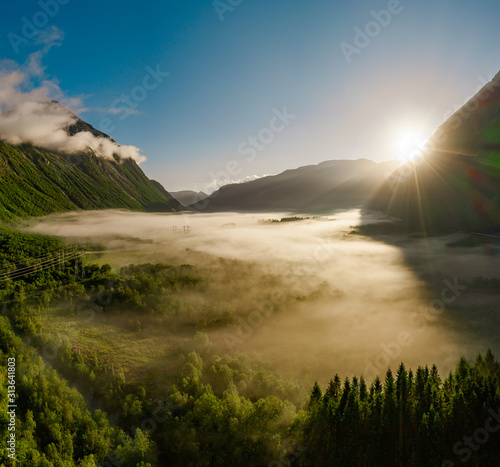 Morning mist over the valley among the mountains in the sunlight. Fog and Beautiful nature of Norway aerial footage. © Andrei Armiagov