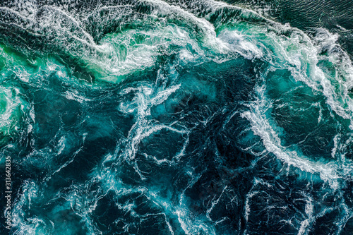 Abstract background. Waves of water of the river and the sea meet each other during high tide and low tide. Whirlpools of the maelstrom of Saltstraumen, Nordland, Norway © Andrey Armyagov