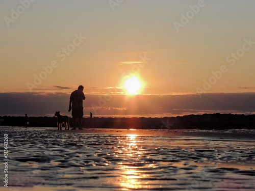 silhouette of man on beach at sunset