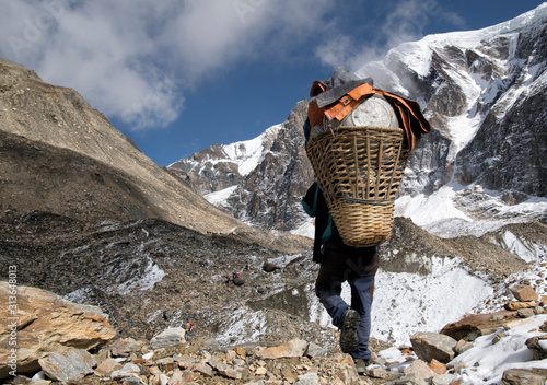 Carrier at Chonbarden Glacier, Dhaulagiri Circuit Trek, Himalaya, Nepal photo