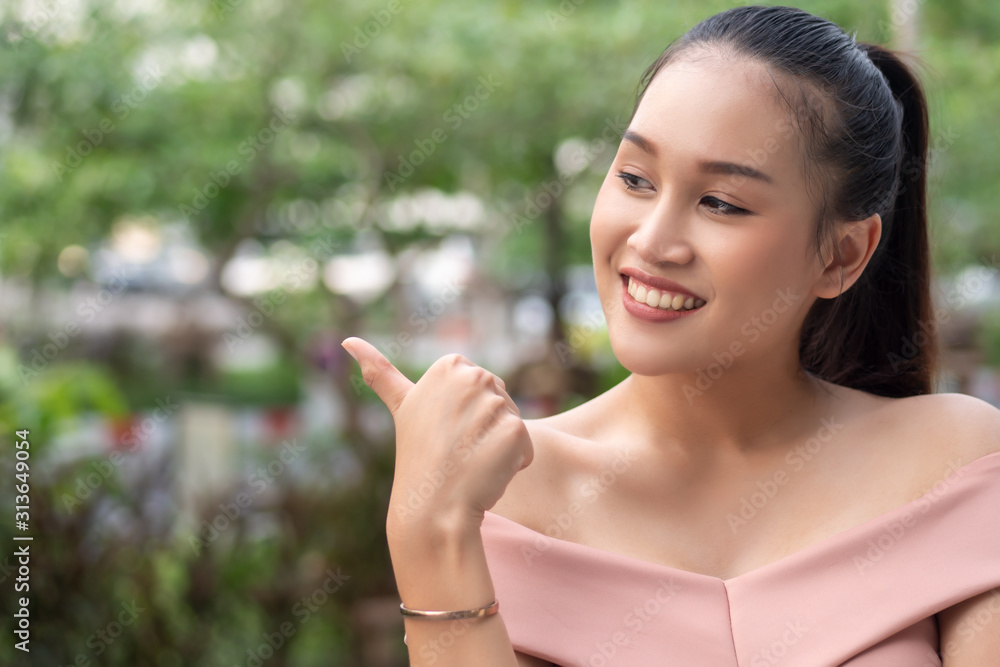 successful girl pointing thumb up; portrait of cheerful smiling woman pointing up approving, yes, ok, good, thumb up gesture; southeast asian woman young adult model successful girl pointing thumb up; portrait of cheerful smiling woman pointing up approving, yes, ok, good, thumb up gesture; southeast asian woman young adult model