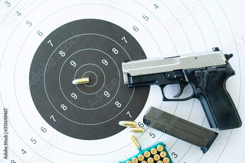 Fotografie Guns with ammunition on paper target shooting   practice