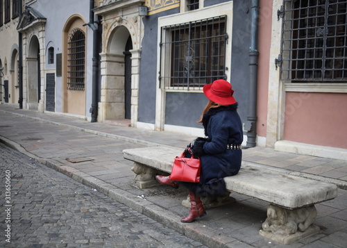 Elegant woman in a red hat in the old town of Warsaw.