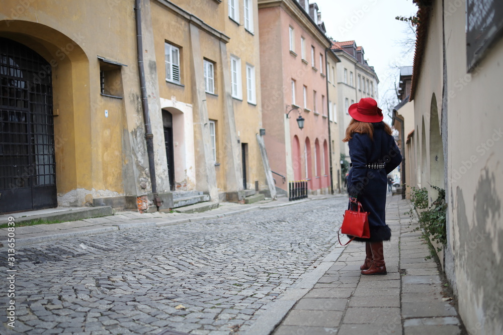 Elegant woman in a red hat in the old town of Warsaw. Elegant woman in a red hat in the old town of Warsaw.