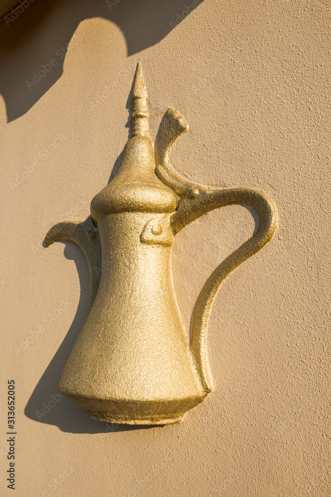 Bas-relief on the wall: Arabic teapot dallah.The shadow of the roof, yellow paint. Bas-relief on the wall: Arabic teapot dallah.The shadow of the roof, yellow paint.