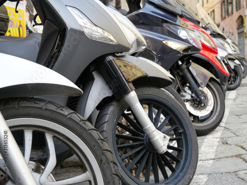 Closeup of motorcycles front wheel parked in the city  in Genoa  Italy.