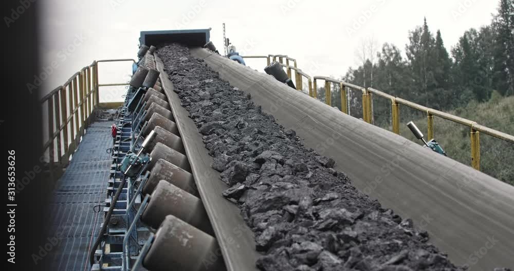 Conveyor belt with coal shooting in slow motion. Closeup there is coal