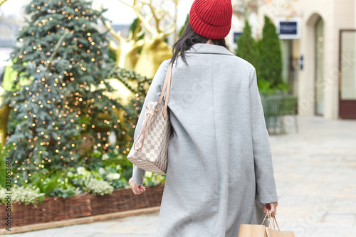 woman doing christmas shopping, is on her back, is unrecognizable