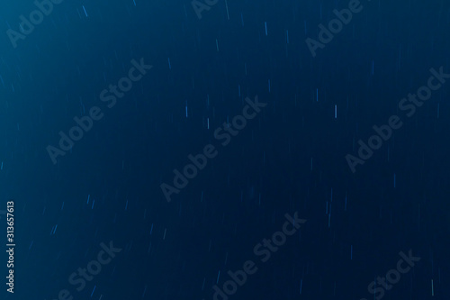 Moving stars at night, dark blue universe background. Long exposure shot. 