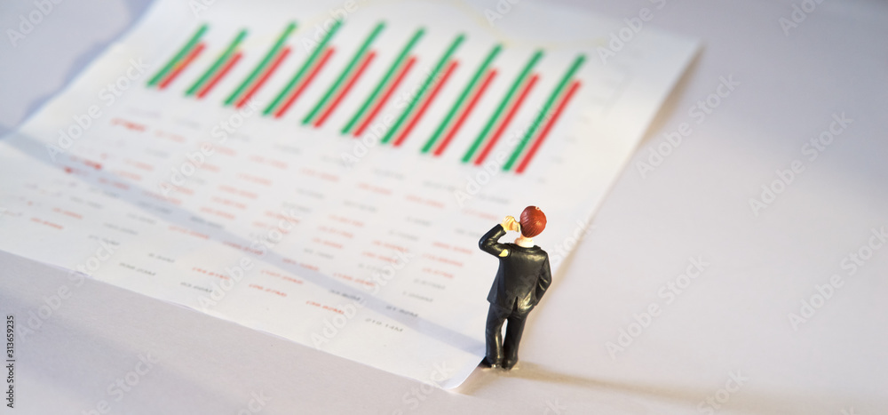 miniature business people and business financial graph data on white paper, business and financial analysis concept miniature business people and business financial graph data on white paper, business and financial analysis concept
