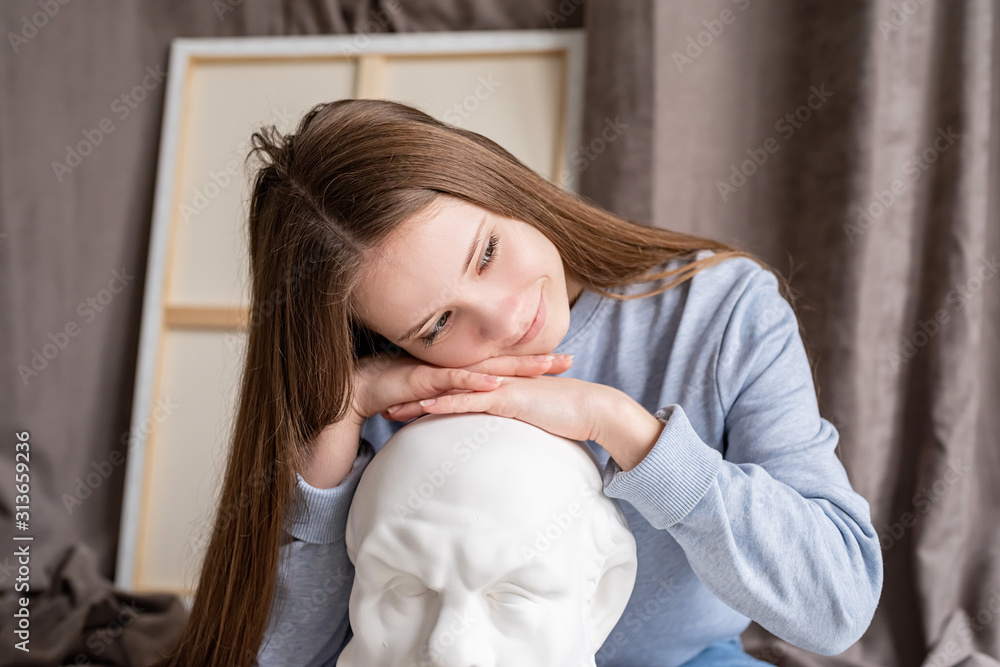 young female artist sitting in her studio with the canvas and gypsum Socrates head young female artist sitting in her studio with the canvas and gypsum Socrates head