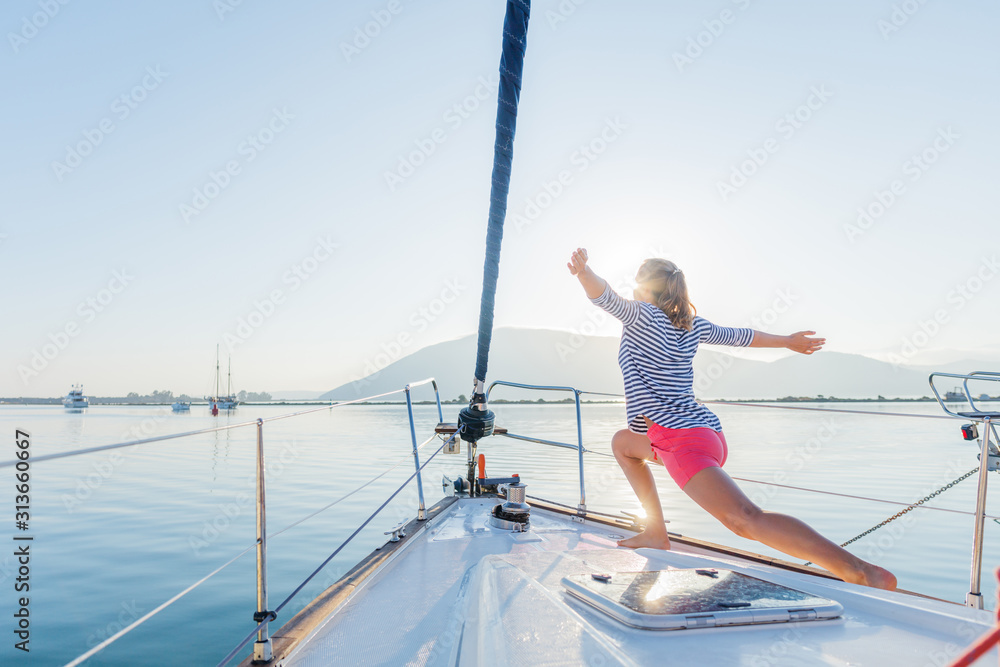 Naklejka premium Girl is practicing yoga on the deck of the yacht boat