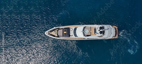 Aerial drone ultra wide photo of luxury yacht with wooden deck docked near port of Port of Fontvieille in deep blue sea, Monaco, France © aerial-drone