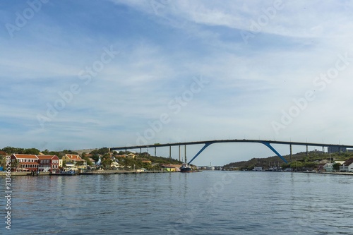 Beautiful view of famous Queen Juliana Bridge. Gorgeous ocean landscape on blue sky background. Willemstad. Curacao.