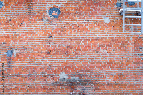an old red brick wall taken down on a cloudy winter day
