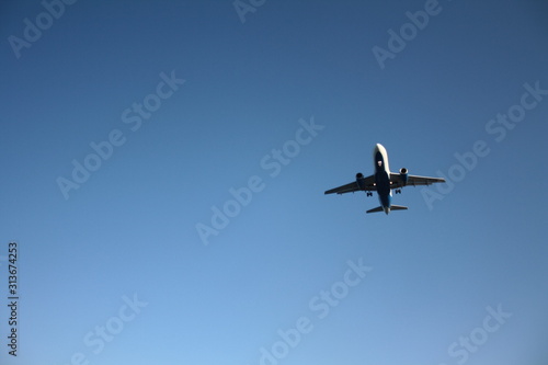 Flying airplane against the blue sky
