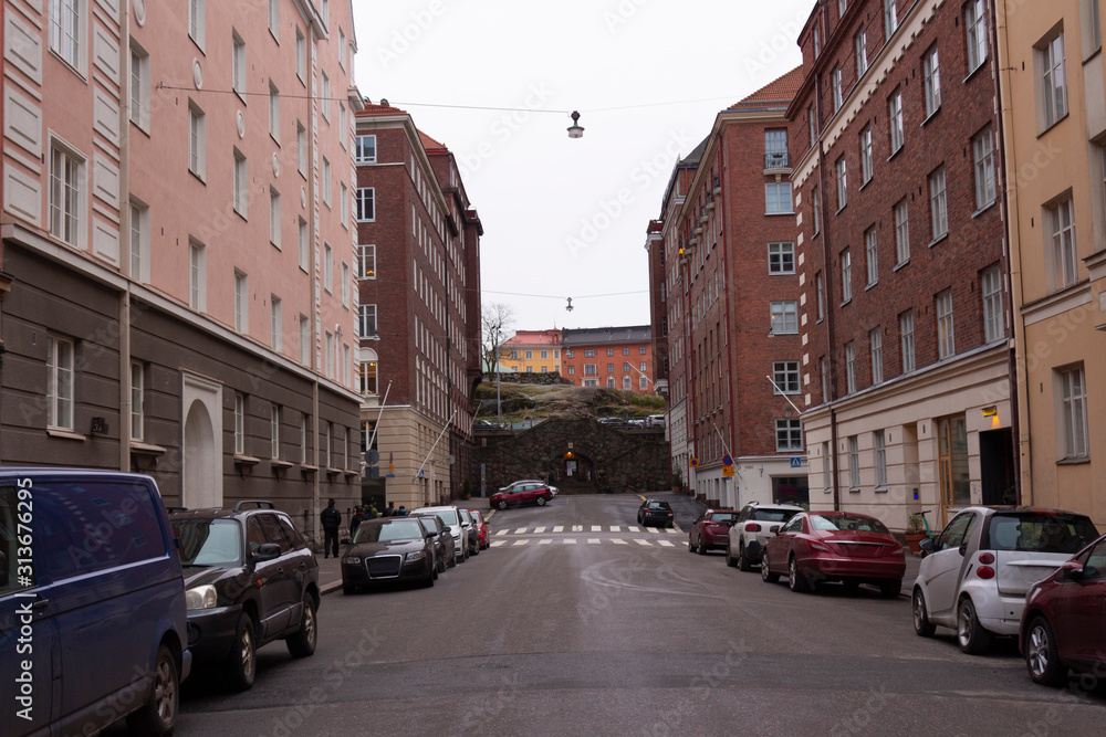 Oxasenkatu street and the entrance to the historic Tempeliaukio church made in a rock in the city of Helsinki in Finland.
