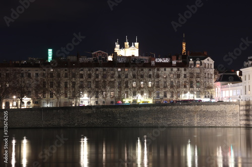 La basilique de Fourvière et la tour métallique à Lyon vus de nuit derrière les immeubles du quai Jules Courmont le long du fleuve Rhône - Ville de Lyon - Département du Rhône - France