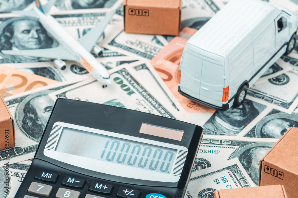 Calculator, lorry, airplane, cardboard boxes on a money background. Cargo Delivery Business Development Concept Calculator, lorry, airplane, cardboard boxes on a money background. Cargo Delivery Business Development Concept