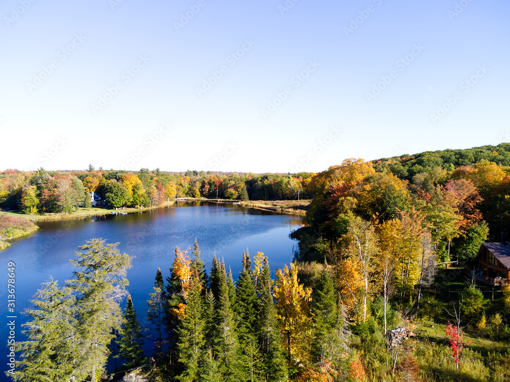 Fototapeta premium autumn landscape with lake and trees on a sunny day with colorful clouds