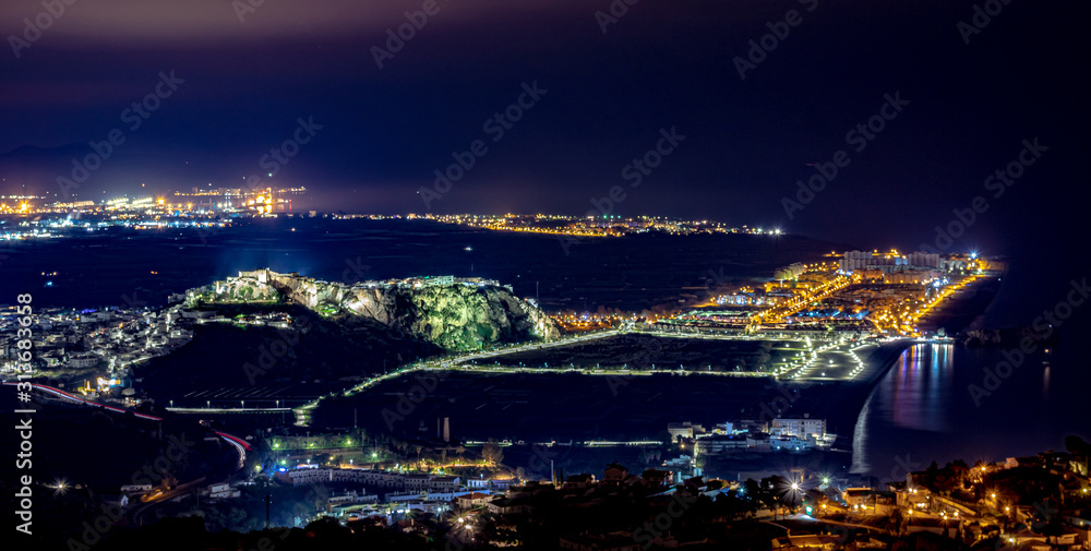 Aerial view of Salobrena, a beautiful Andalusian village at night with beautiful lights, the sea, and a castle over the village