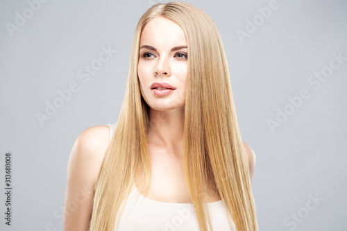 Beautiful blonde woman with shiny long straight hair and natural fresh make up. Fashion beauty portrait isolated