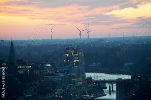 Sonnenaufgang über Bremen mit Windenergie am Horizont