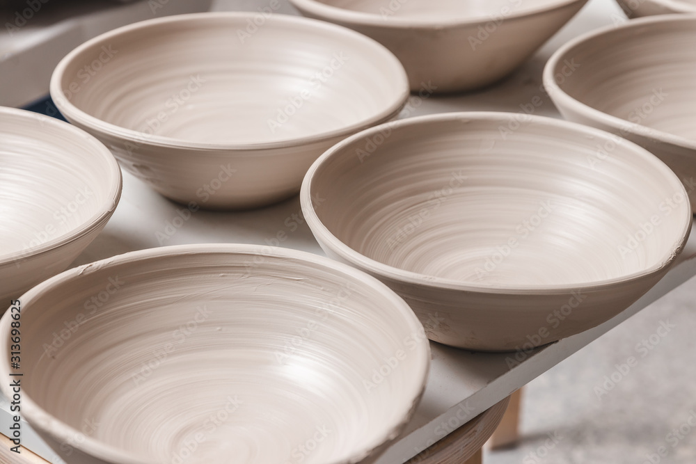 oil semester cell raw ceramic bowls made from white clay on the potter's wheel circle waiting  for putting in the pottery kiln, concept of manual work, creativity and  art, vertical photo Stock Photo | Adobe