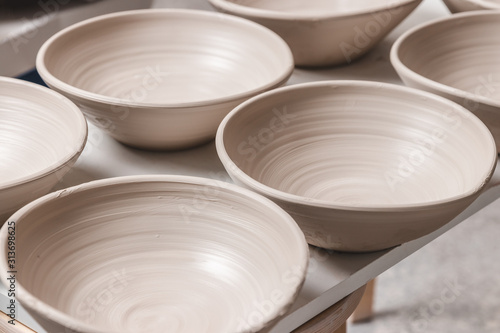 Tableau sur toile raw ceramic bowls made from white clay on the potter's wheel circle waiting for