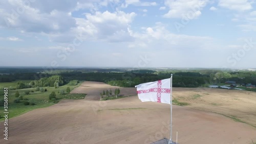 Orbiting around Seto flag waving in wind on top of a tower in Setomaa. Aerial footage. Orbiting shot. photo