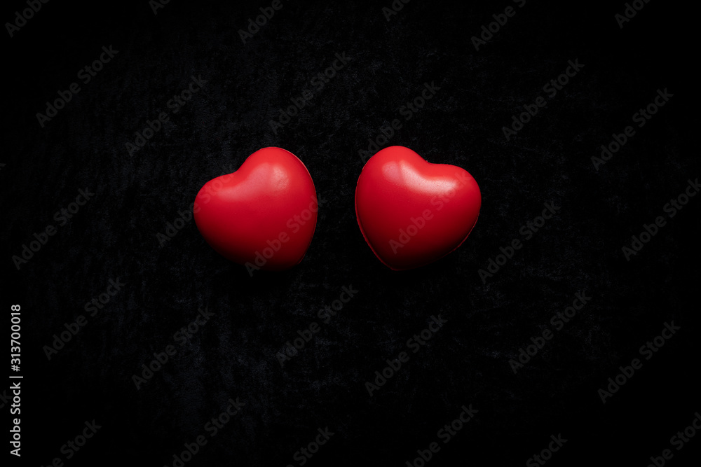 two red hearts on a black velvet background two red hearts on a black velvet background